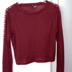 Långarmad vinröd tröja med pärlor - Långarmad vinröd tröja med pärlor längs armen. Kroppad modell. Från H&Ms divided avdelning 
