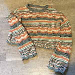 Stickad tröja - Stickad tröja i riktigt fina färger och lite utsvängda armar. Använd en gång, ser helt ny ut. Den är i riktigt bra kvalitet och sitter skönt. 