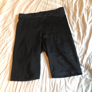 Cykelbyxor Stolek M  - Svarta cykelbyxor i glansigt material från H&M (DIVIDED). 