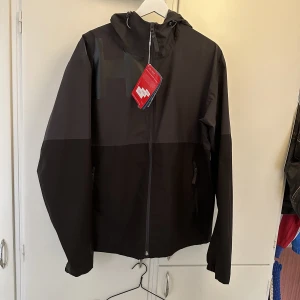 Ny Helly Hansen regnjacka  - En väldigt snygg regnjacka av hög kvalitet i nyskick. Endast testad, prislappen sitter kvar.  Köpt för 1700kr  Skön, lätt o smidig. Väger endast 390gram!  Vattentät, vindtät och andningsbar.  Lufthål i armhålan för ventilation. Jag är 180cm 72kg.