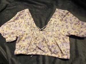 Blommit topp - Söt blommig topp med snörning i ryggen från H&M som endast kommit till användning en enstaka gång.🌸