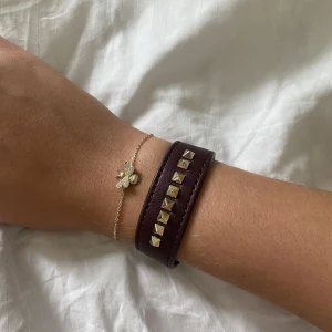 Vinrött armband - Superfint armband från Edblad med guldiga nitar! Köpt för några år sen så väldigt unikt💞