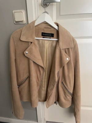 Mocka jacka i get skinn - Beige läder jacka i äkta get skinn  Använd 2 gånger bra kvalitet  L men går att användas av m också