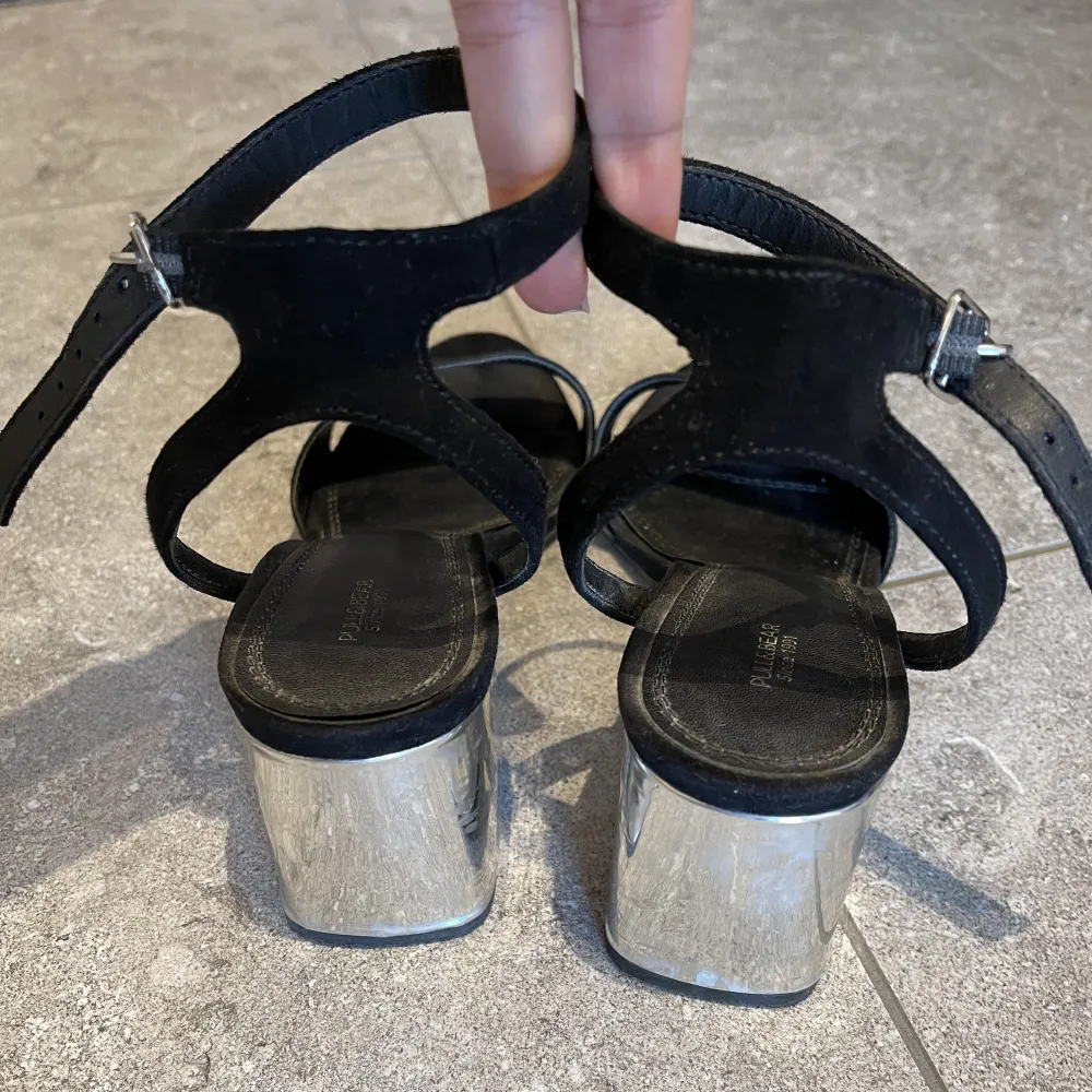 Sandals with 7 cm heel. The fabric is black velvet and the heel is silver, giving it a touch of shine, they tie at the ankle and are very comfortable. They are clean with no defects. Skor.