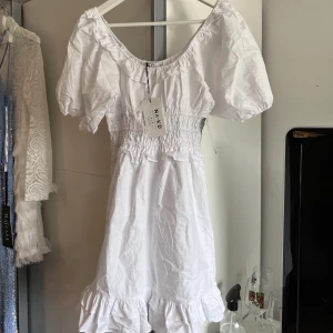 Studentklänning - Jättefin studentklänning ifrån nakd. Väldigt mkt resor så den funkar nog Xs-m. Helt ny, prislappen kvar