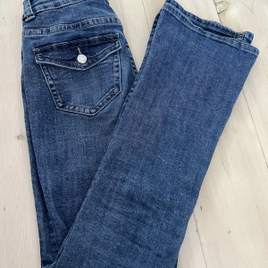 Lågmidjade jeans med vintage fickor - ⚠️KVAR⚠️ Säljer på dessa lågmidjade bootcut jeans från Gina. Det är storlek 32 men dom passar 34. Sömmen längst ner är uppsprättad i ett försök att få dom längre, kan skicka bild!! Använda två gånger dvs dom är som nya. Skriv vid intresse eller frågor💕