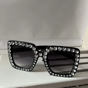 Solglasögon  - Solglasögon med stenar runt och är köpta utomlands för några år sedan. Har inte fått användning av dessa så de är fortfarande i nytt skick. 