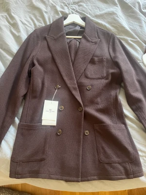 Kavaj från John Henric - En dubbelknäppt stickad kavaj från John Henric  Helt ny med tags, aldrig använd. Storlek: Medium Färg: Brun  Nypris: 1499kr Pris: 800kr  