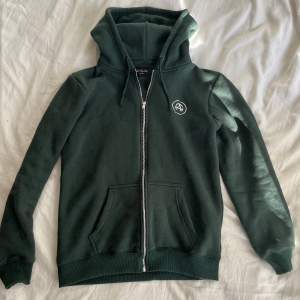 All Cap One Hoodie med färgen mörkgrön. Knappt använd, men väldigt schysst hoodie som säljs för ett bra pris!🫵🏽