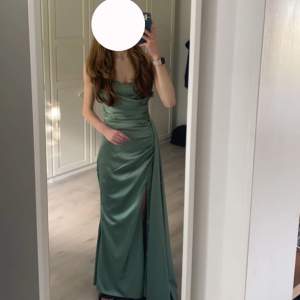 Superfin grön klänning som är använd en liten stund på ett bröllop. Klänningen har en slits och ett litet släp vid ena höften. Hör av dig för fler bilder!