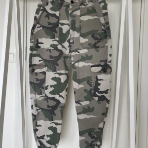 Militärbyxor - Ett par coola militärbyxor från Pull&Bear som använts flitigt men som tyvärr inte kommer till användning längre. Resor längst ner. Lite urtvättad färg. Sitter jättefint på en S. Hela och rena. Kan skicka fler bilder. 