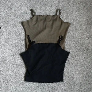 Toppar - 2 stycken supersnygga toppar från Bikbok. En i svart och en militärgrön. (bandet på den svarta har blivit lite konstigt). Båda i storlek S. 