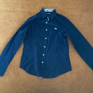 Burrbery skjorta  - Tyvärr är det dags för mig att sälja min Burrbery skjorta. Den är använd fåtal gånger, bara vid speciella tillfällen. Den saknar skador och fläckar!