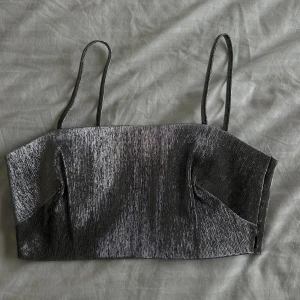 Silver topp - Silvrig glansig topp med dragkedja på sidan, helt oanvänd! 