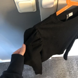 Tröja med puffaxlar - Svart långärmad topp från hm men puffaxlar. Använd 1 gång! Köptes för 199