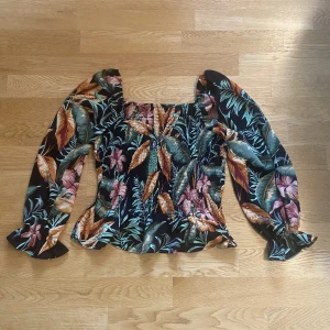 Blus - Långärmad blus med exotiskt/blommigt mönster och fyrkantig urringning 💚❤️🧡🖤 Frakten blir 45 kr, men kan mötas upp