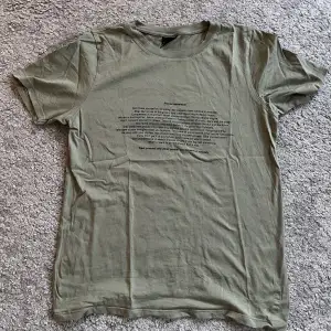 Militärgrön T-shirt med tryck från Ginatricot i strl S. Använd fåtal gånger, i nyskick. 