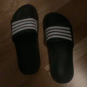Prima tofflor  - Adidas tofflor med ett extra streck vilket tyder på dominans och rikedom först till kvarn
