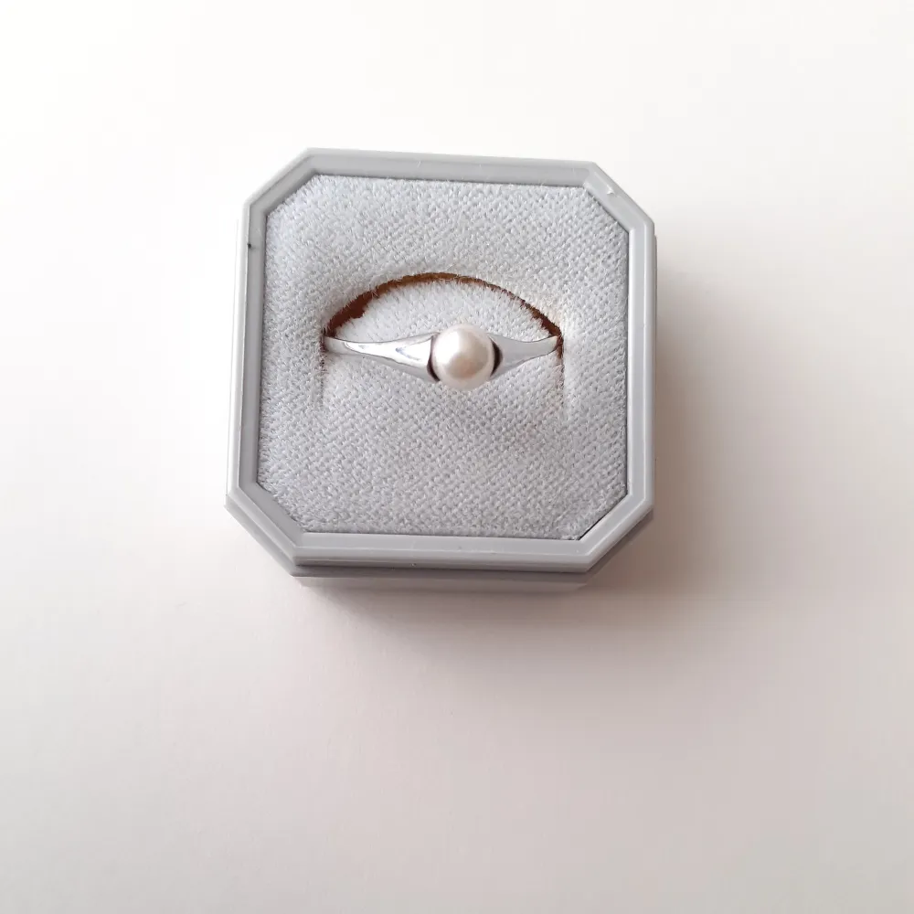 Ring i äkta silver med vit pärla. Helt oanvänd och i nyskick. Storlek 65 (2 cm i diameter)  Frakt: 15 kr  Ask: 10 kr (valfritt). Accessoarer.