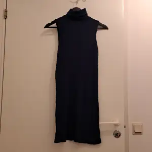 Tajt mörkblå klänning med krage. Utan ärmar