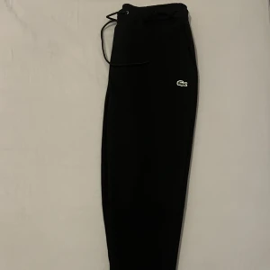 Oanvända Lacoste byxor i perfekt skick! - Jag säljer dessa snygga Lacoste byxor i storlek M som tyvärr var för små för mig. De är helt nya och har aldrig använts. Perfekt för den som uppskattar stil och komfort. Priset är 350kr. Hör av dig om du är intresserad eller har några frågor. Tack!" 🙏  