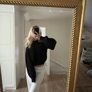 Stickad tröja - Säljer denna svarta stickade tröjan från NA-KD då den inte kommer till användning längre. Knappt använd och i superskick! Är lite croppad i modellen. Skriv för fler bilder💕
