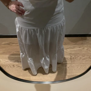 Lång vit kjol - En vit långkjol köpt på Sellpy. Jag är 154 cm men är för lång för mig. Midjan på kjolen (som är tänkt att sitta på höften/nedre dagen av magen) går upp till precis under brösten på mig 🤍passar S/M