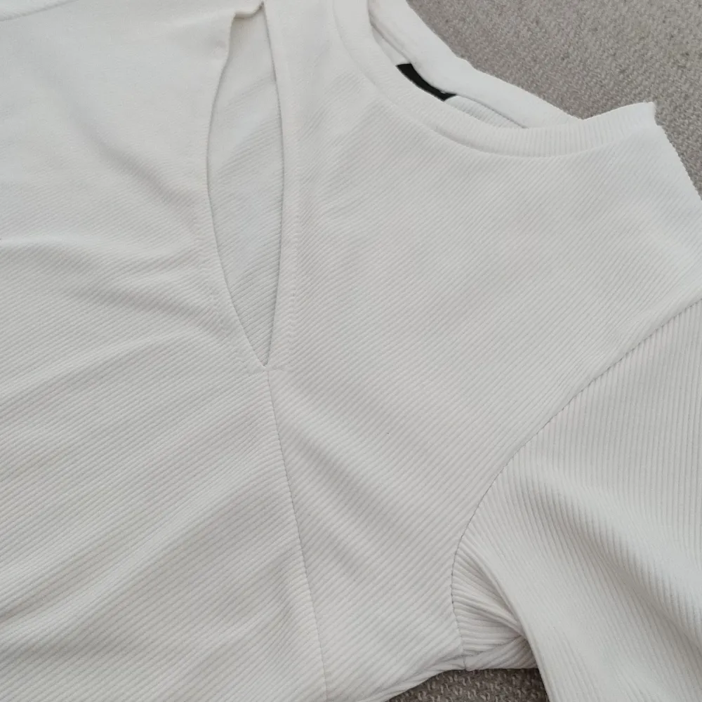 Cool vit tröja med skärning från Gina Tricot. Storlek small. Lätt ribbat tyg. Som ny! . Toppar.