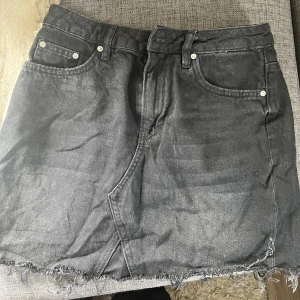 Kjol  - Svart/grå jeanskjol i storlek 36 men liten i storleken. 