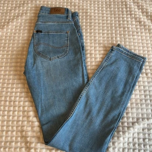 Jeans LEE - Superfina jeans från LEE, inte använts sen 3 år tillbaka pga för små. Något åt det Ljusblåa hållet i färg. Innerbensmått ca 70cm, midja ca 58cm  men lite stretchiga. Storlek i byxan står 25/31. Bara att skriva om du har frågor🫶