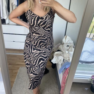 Klänning - Lång klänning med zebra mönster, är sparsamt använd