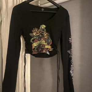 Topp från Urban med tryck  - Knyte på sidorna ganska kort, funkar för storlek M. Tryck på ena ärmen. Använt en gång