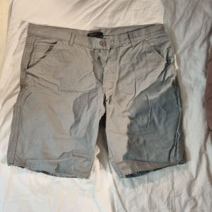 Täckande shorts - Grå shorts lite fnasiga i underkant se bilder. Upplevs vara i storlek L