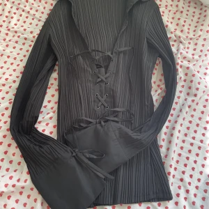 Blus med snörningsdetaljer - ”gothic” blus/topp med vida ärmslut och snörning i bröstet och i ärmarna