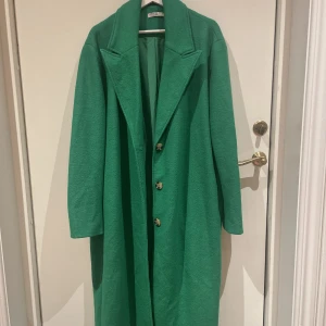 Kappa  - Grön lång kappa från Gina. Super cool och faller tungt! 