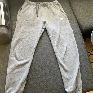 Nike byxor  - Ett par mörkgrå Nike byxor i bra skick som ej kommer till användning eftersom dem inte passar. Storlek m. 299 kr (nypris 600) 
