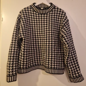 Stickad tröja  - Hundtandsmönstrad stickad tröja från Arket. 100 ull. Storlek xs