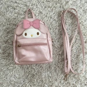 My melody väska - Söt my melody väska, köpt för 300kr men säljer för halva priset för att ja har haft den ett par gånger och dragkedjan har åkt av, kommer med ett band så man kan ha den som en ryggsäck eller på sidan, fin skick bara att metallen är lite brun