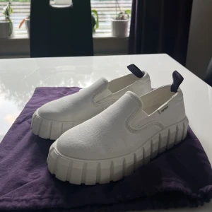 Eytys vita slip ons - Säljer ett par vita Eytys i en slip on modell i storlek 39. Endast använda en gång men säljs då de är alldeles för stora. Dustbag medföljer om det önskas