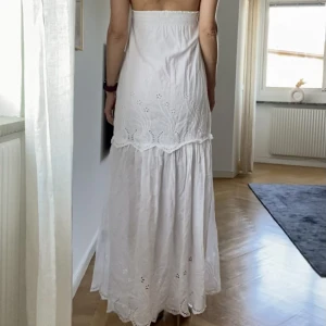 Vit sommarklänning - Klänning i bomull med broderade partier. Storlek 34, sann till storlek men kan bäras av en 36a eftersom det är stretch i ryggpartiet. Jag (på bilden) ligger mellan 34 och 36.  Behöver strykas men i övrigt inga skavanker! Tyget har fler lager i toppdelen.