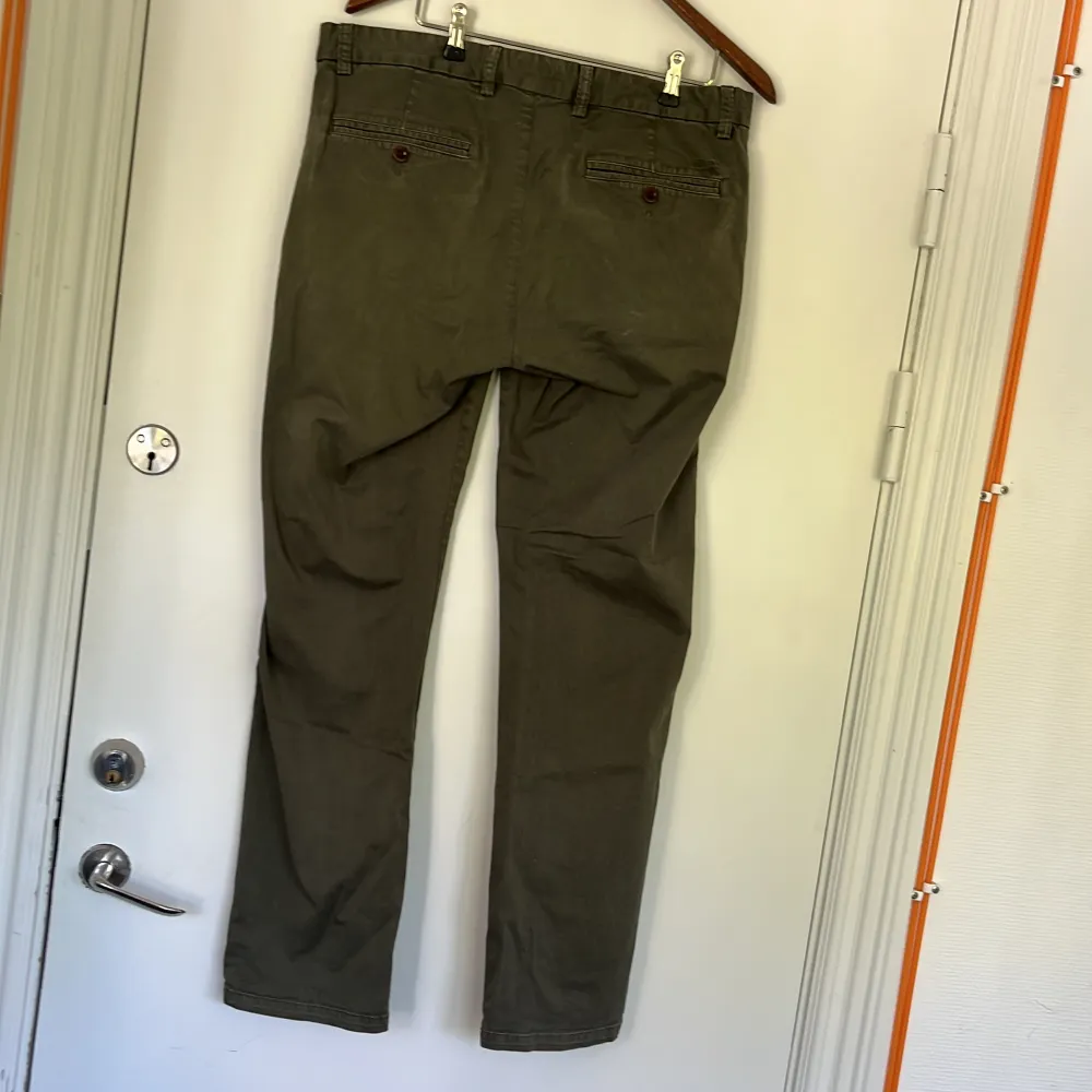 Olive-coloured chinos.  Model: Low waist, Narrow Fit. Jeans & Byxor.