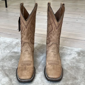 Cowboyboots - Snyggaste cowboybootsen i läder från Corral köpta från Bootbarn. Helt nya!!!! Strl: 7 1/2 = 38. Små i strl så liknar mer 37. För små för mig och är anledningen till att jag säljer dessa drömmiga boots😍🥲