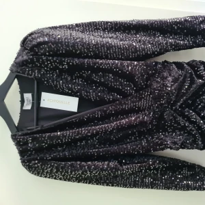 Paljettklänning  - En fin svart paljettklänning i storlek L. Aldrig använd.