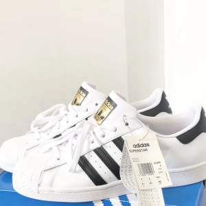 Adidas SUPERSTAR SHOES ny oanvänd. Storlek:43 1/3  Färg : Vit /svart/guld   Kan skickas med Postnord spårningens packet inom Sverige  Ordpris : 1299 kr