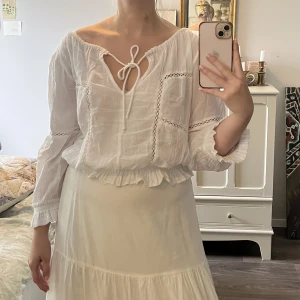 Vit blus - Luftig vit blus. Kan knytas framtill och justeras i halsringningen.