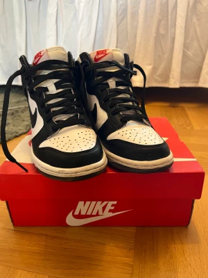 Nike dunk High (GS) - Nike dunk high i svart och vit. Köpta 2021. Säljer pga att jag inte använder dom längre. De är använda några gånger men är i ett bra skick. Fråga gärna om fler bilder så att jag kan visa skicket. 