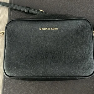 Micheal Kors Väska - Säljer min svarta läder Micheal Kors väska! Köpte den i Micheal Kors butiken i Stockholm 2019 för 2100 kr. Jag har inte kvar kvittot men jag har ett care card som kom med väskan. Den har använts en del men är i nästan ny skick. Guldet på sidan av väska har försvunnit lite men syns knappt. Skriv privat för fler bilder💕🤘🏽
