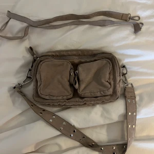 Väska  - Väska köpt på Gina Tricot.  Två stora fack och två små på framsidan. Längre band finns med. 