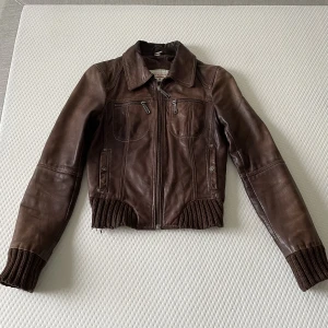 Brun skinnjacka  - Jättefin brun skinnjacka i äkta läder i storlek s. Lädret har åldrats med ett mycket fint mönster. Den här är såå fin jag älskar muddarna!! 