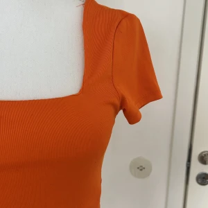 Tajt topp  - En jättesnygg, söt och sexig orange topp från newyorker. Super skönt material.